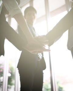 Business professionals placing hands on each other indicating teamwork